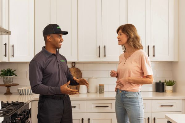 Terminix technician consulting a client in their kitchen
