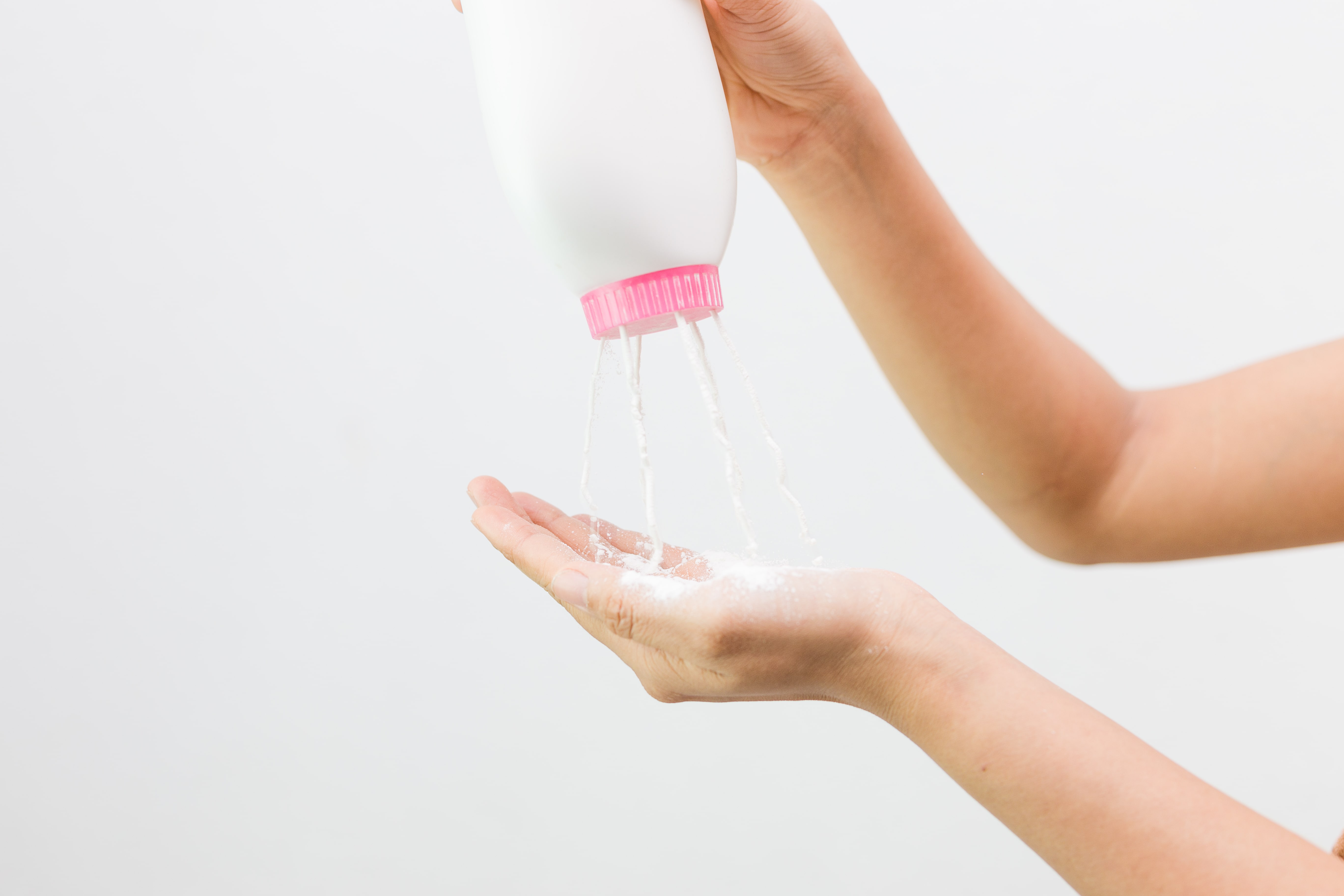 baby powder being squirted into a hand
