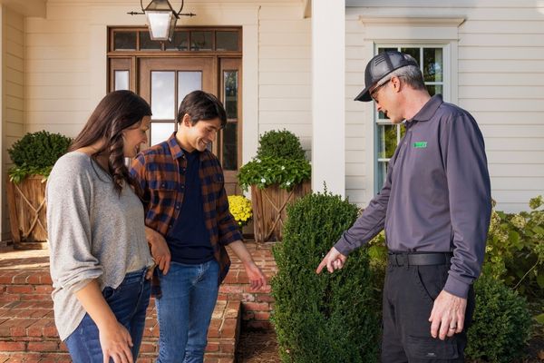 Terminix technician pointing at area with homeowners