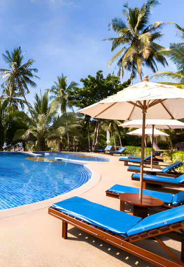 Hotel outdoor lounge seating under umbrellas next to a pool