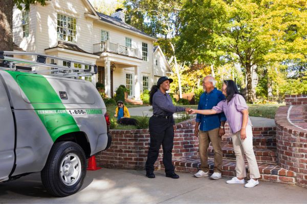 Colleague shaking hands with costumers outside of the house