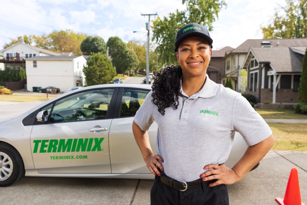Terminix technician in front of a car